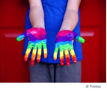Frau mit Händen bemalt in den LGBT Farben
